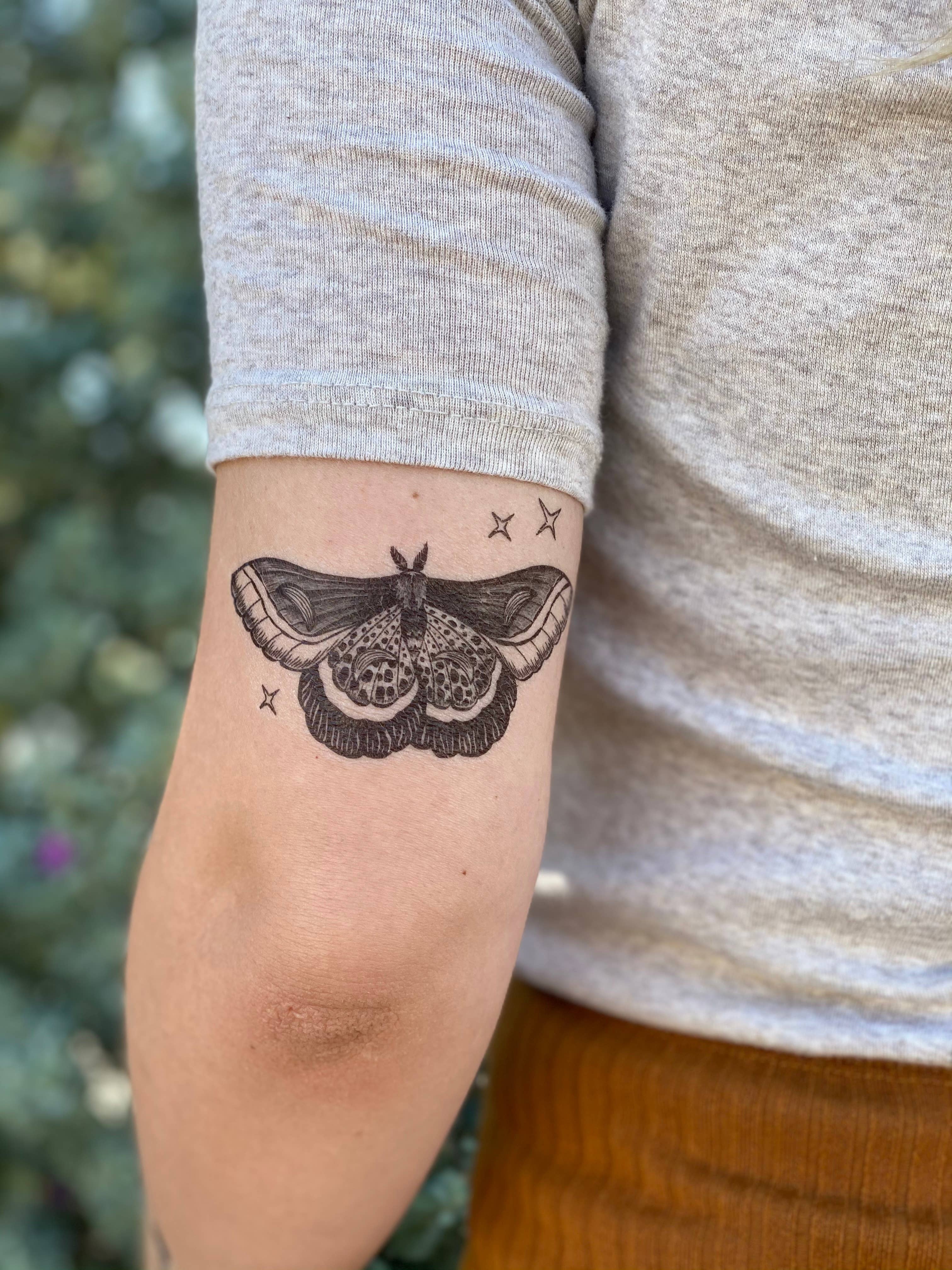 Large moth tattoo done on the upper back.